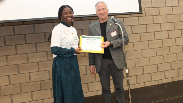 A ToLSO participant accepting a certificate on stage.