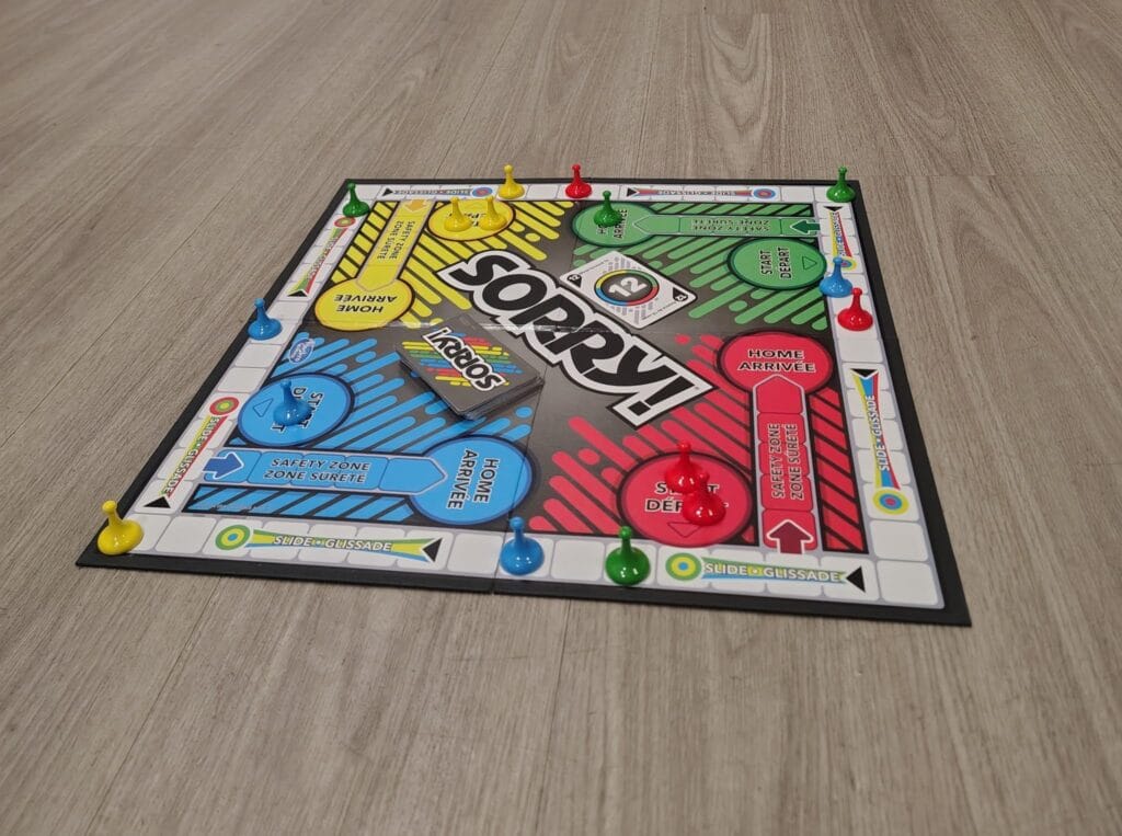 A Sorry board game set out on the wooden floor at Pilgrim Lutheran Church, counters in their starting corners ready to play