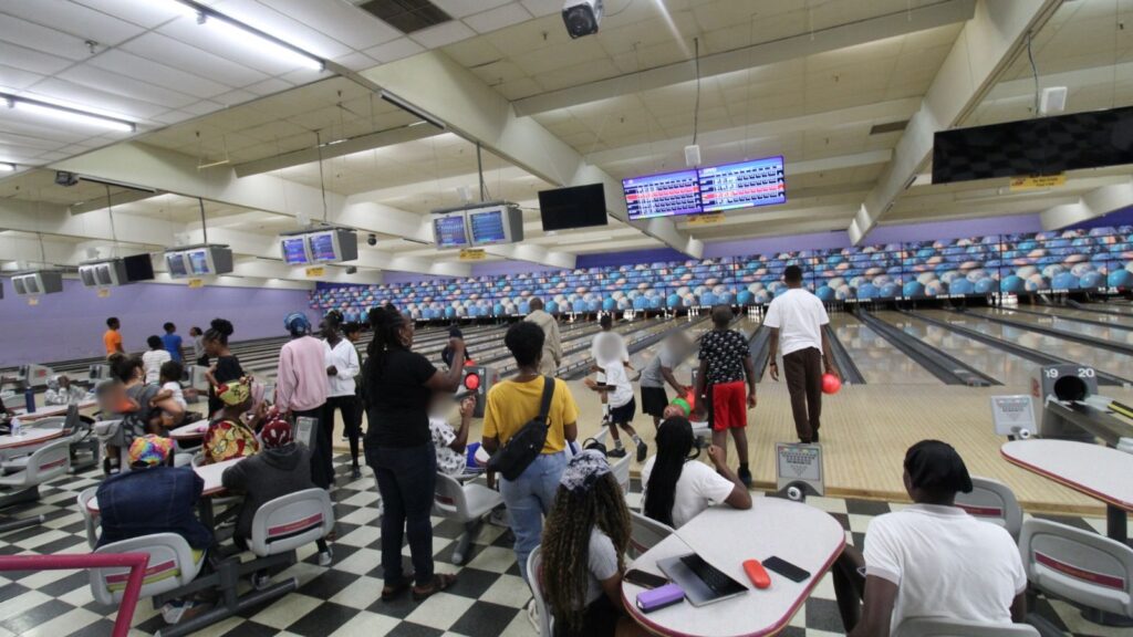 Bowling lanes at the alley with players and families along the approach