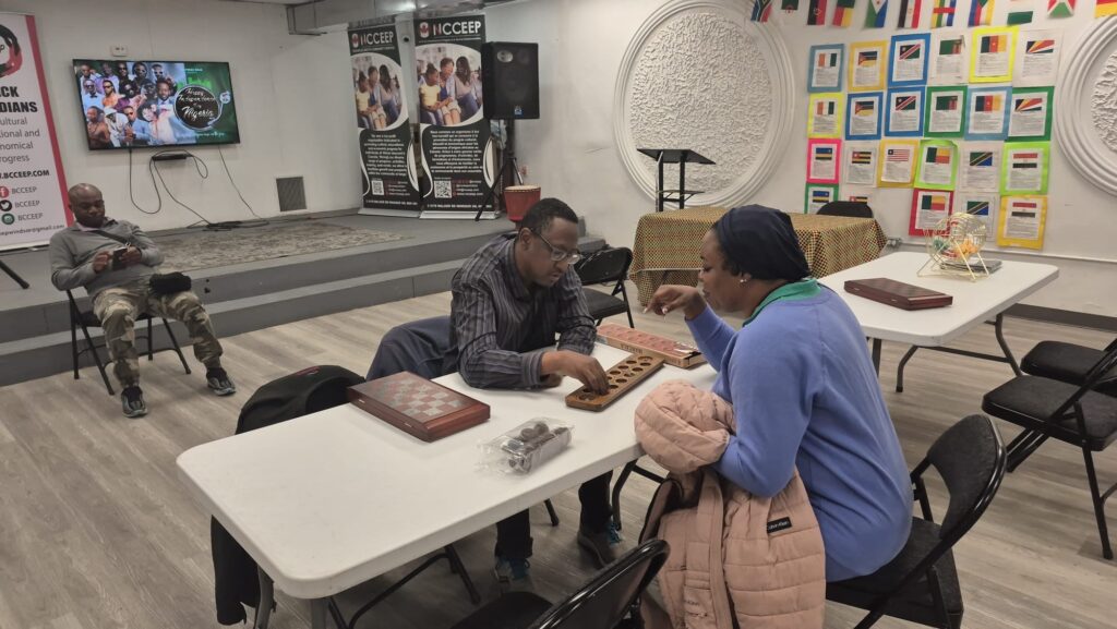 Two attendees playing a board game across a table at the WEBS Centre session