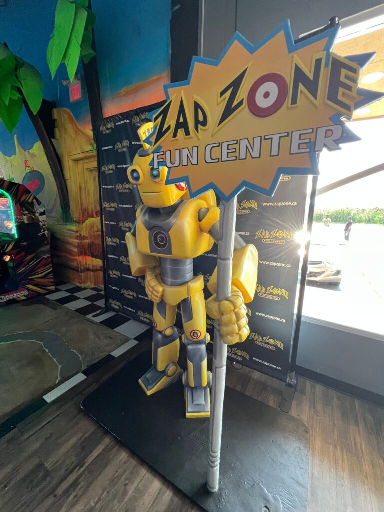 The Zap Zone mascot figure standing beside the entrance doors